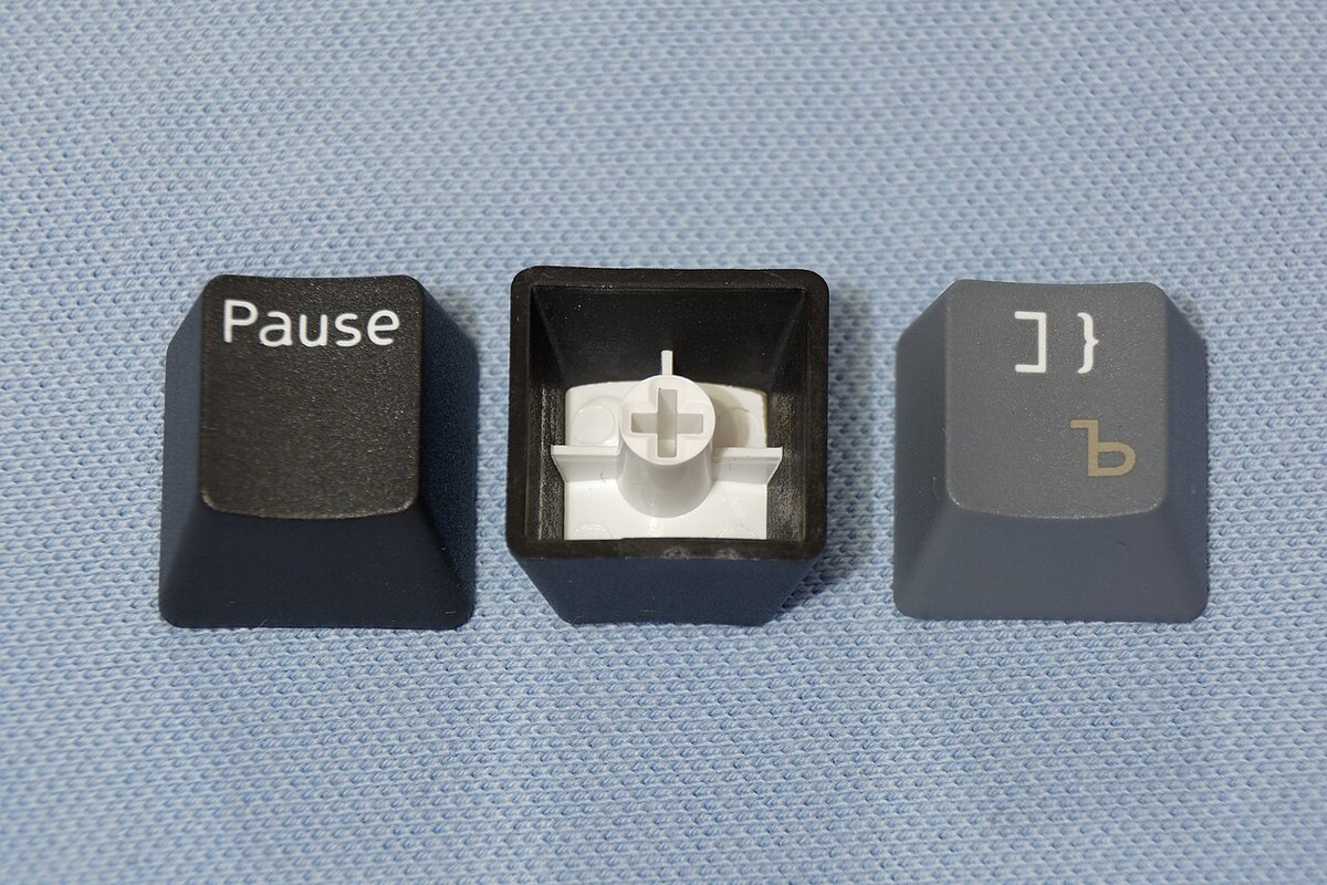 Các keycap đúc hai lớp nhựa được cắt ra cho thấy lớp ký tự xuyên sâu bên trong