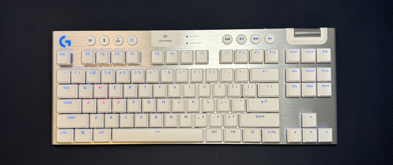 Ảnh chụp thực tế phiên bản màu trắng bạc của bàn phím cơ không dây Logitech G915 X TKL đặt trên bàn làm việc.