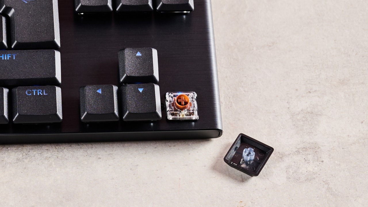 Ảnh chụp cận cảnh cụm phím điều hướng của Logitech G915 X TKL với một keycap được tháo ra để lộ switch cơ học low-profile Logitech GL bên dưới.