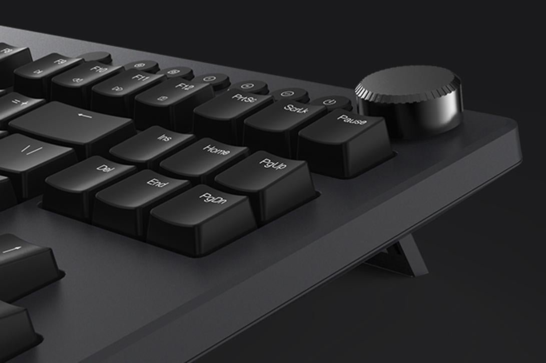 Cận cảnh núm xoay âm lượng kim loại ở góc trên bên phải bàn phím iKBC Table-E 401