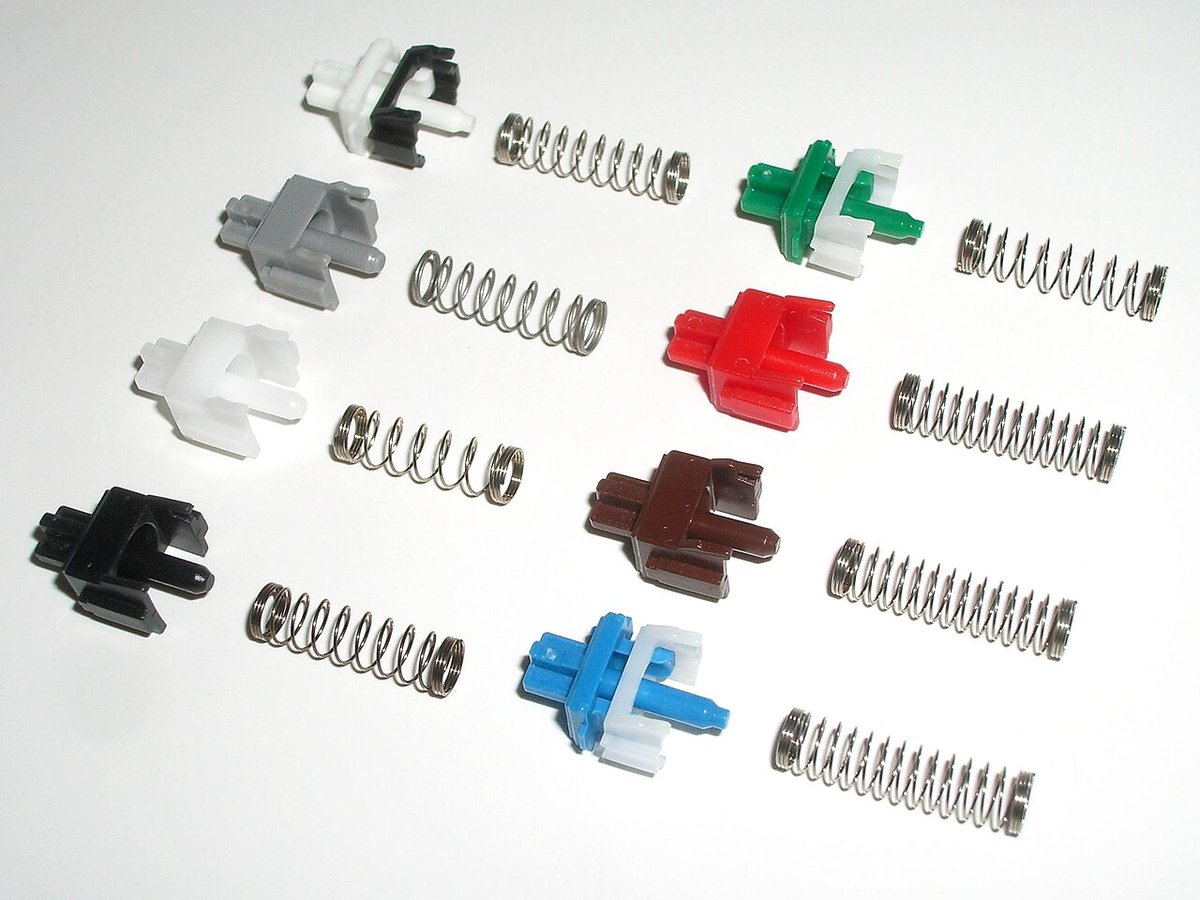 Các bộ phận trục trượt và lò xo của nhiều switch Cherry MX khác màu xếp thành hàng